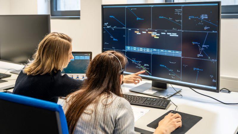 people looking at data on a monitor