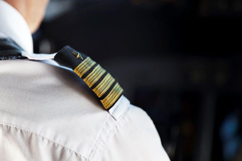 golden pilot badge worn by a pilot