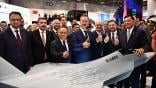 Officials in suits giving thumbs up around model Kaan fighter