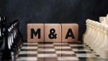 "M&A" blocks on a chess board
