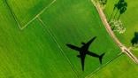 airplane flying over green field