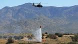 Black Hawk helicopter drops water on a fire